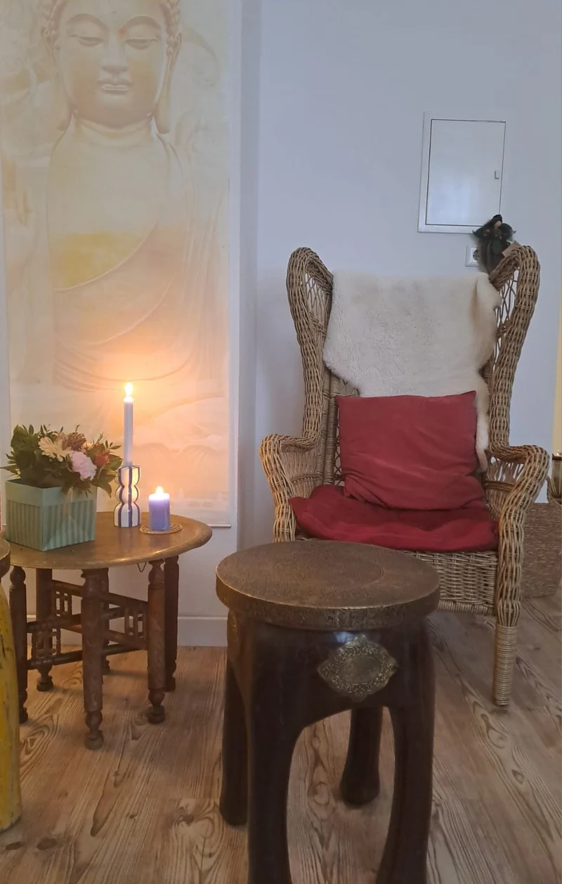 Ein ruhiger Sitzplatz mit Trommel, Blumen und Kerzen im Löwenzahn-Studio.